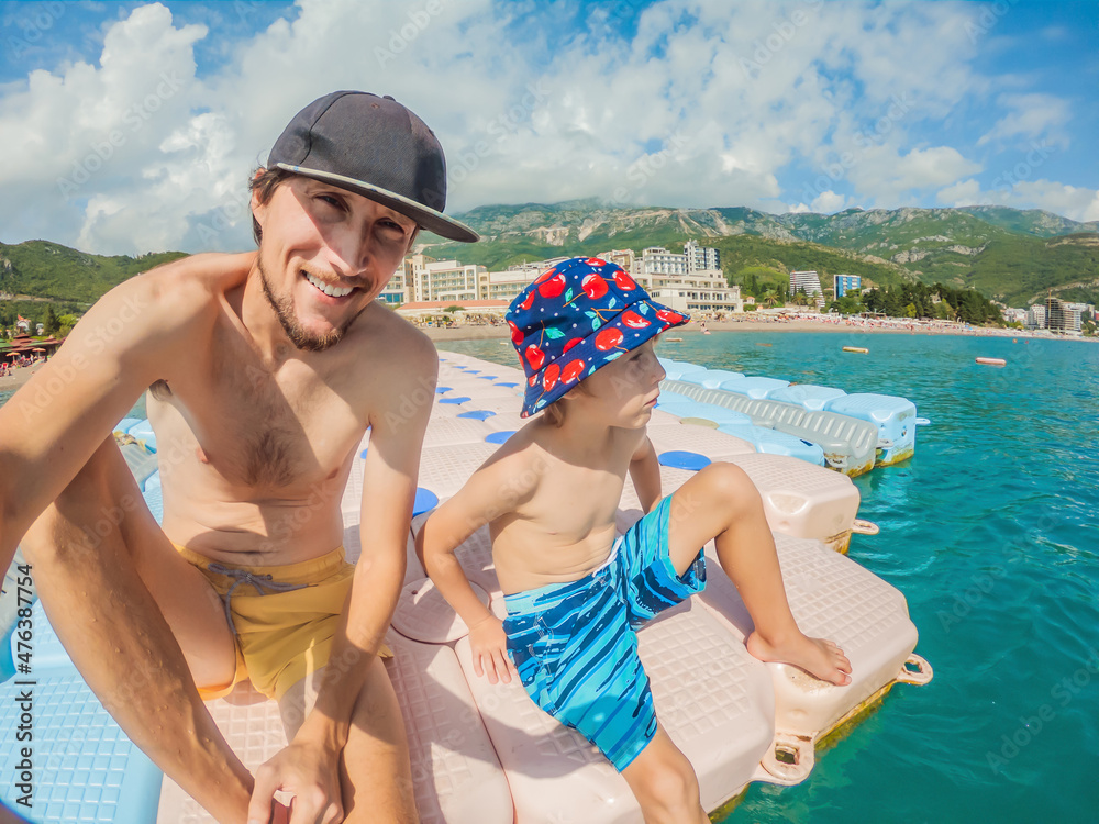 Father and son in Montenegro seashore, Becici resort, view from the sea