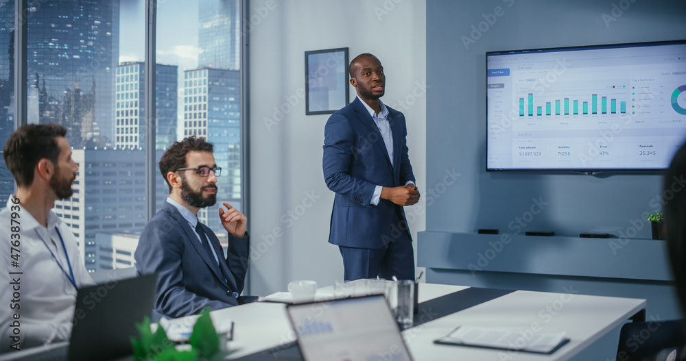 Diverse Office Conference Room Meeting: Successful Black Executive Director Presents e-Commerce Fintech Growth Statistics to a Group of Investors. Wall TV with Big Data Analysis, Infographics Diverse Office Conference Room Meeting: Successful Black Executive Director Presents e-Commerce Fintech Growth Statistics to a Group of Investors. Wall TV with Big Data Analysis, Infographics