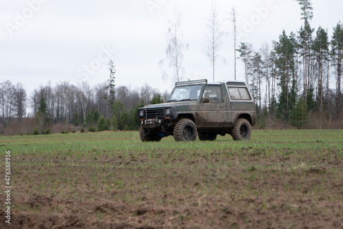 A 4x4 SUV vehicle on the off-road terrain and wet dirt route. Transportation and sport adventure concept