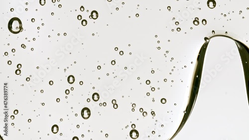 Transparent Cosmetic Gel Fluid With Molecule Bubbles Flowing On The Plain Surface. Macro Shot. High quality 4k footage