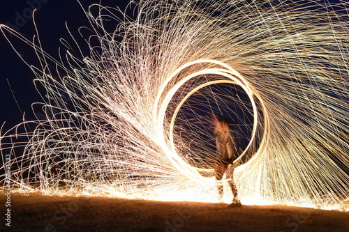 Iron wool circle drawing light fireworks. Burning Steel Wool spinning, Trajectories of burning sparks at night. Movement light effect, steel wool fire hoop. long exposure light painting, Pyrotechnic