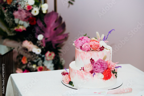 Pastel pink layer wedding cake decorated with white peony flowers