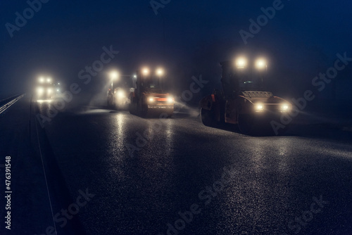 Rolling asphalt at night with headlights. Road construction.