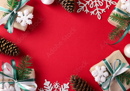 Christmas frame with gifts, cones, snowflakes on red background. Xmas Greeting card. Happy New Year, Copy space