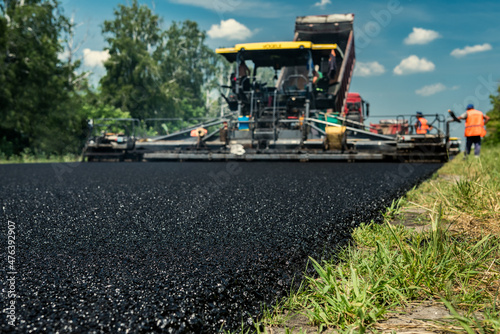 Layer of new hot asphalt laid by paver. Road construction.