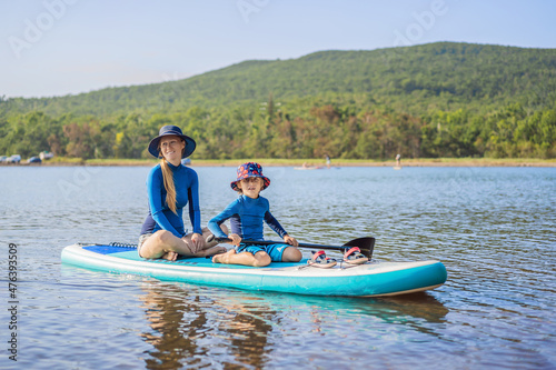 happy family of two, mother and son, enjoying stand up paddling during summer vacation