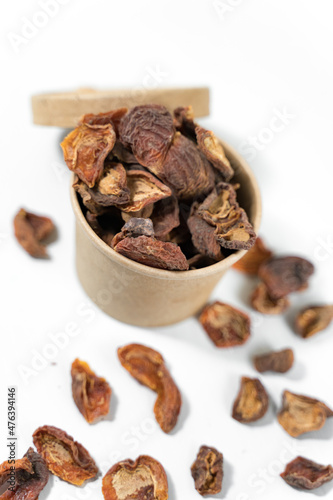 Dried apricots in a paper cup with a lid over white background. Top view.