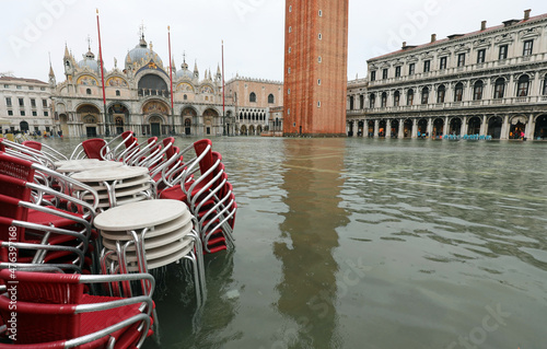 chairs of the alfresco cafe in Saint Mark Square  flooded during high tide in  Venice photo