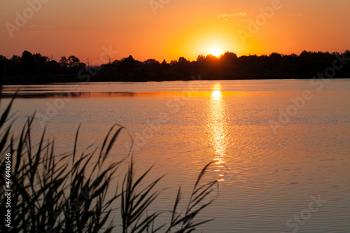 lake during sunset with yellow-orange sky