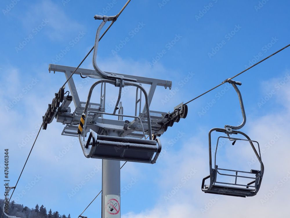 Chairlift ski lift in winter. Close up of an empty chair in a ski lift. The chairlift is out of order. Closed ski resort. Chairlift ski lift in winter. Close up of an empty chair in a ski lift. The chairlift is out of order. Closed ski resort.
