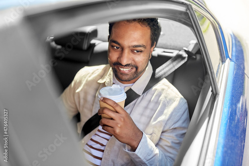transportation and people concept - happy smiling indian man with takeaway coffee on back seat in taxi car © Syda Productions