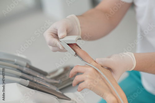 Close up of doctors hands with pulsometer photo