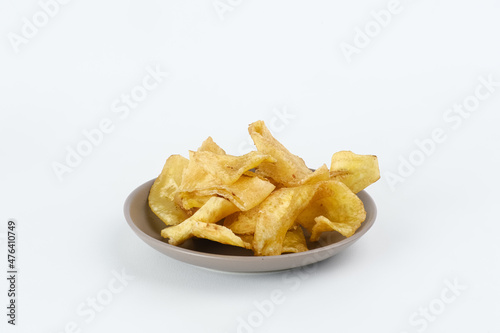 Heap of dried banana chips snack on white background. Selective focus image, blurred background.