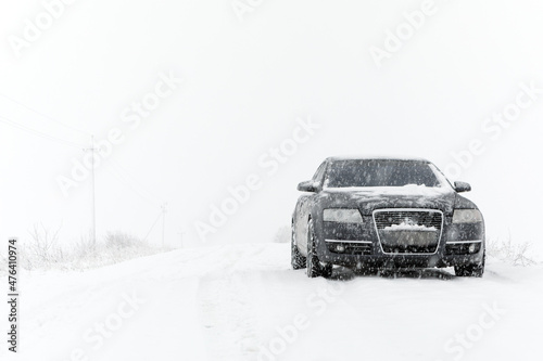 Winter landscape with road and black car
