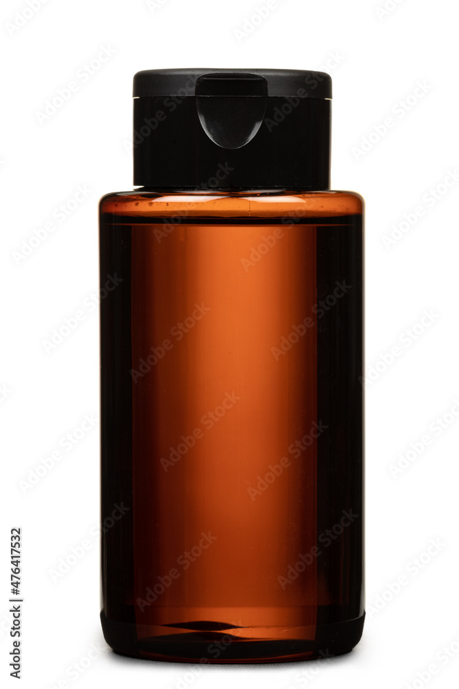 Brown colored plastic transparent bottle with black cap, filled with liquid, no label, isolated on white background Brown colored plastic transparent bottle with black cap, filled with liquid, no label, isolated on white background