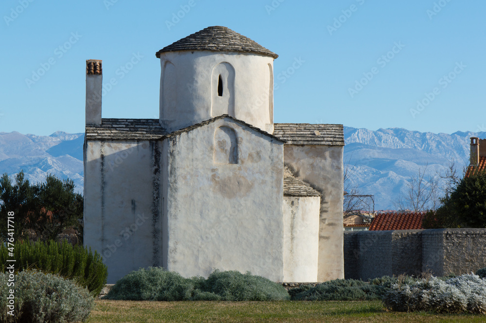 Nin, Croatia - Famous monument, church of Holy Cross and Velebit mountains in the background; preserved pre-romanesque architecture