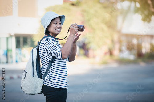 Asian woman taking picture photo with digital camera in city, Tourist asian female smiling using camera to take photograph on travel vintage piture style, lifestyle holiday travel on walk street. photo