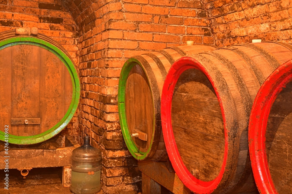 Foto de Wine barrels stacked in the old cellar of the winery. Barrels