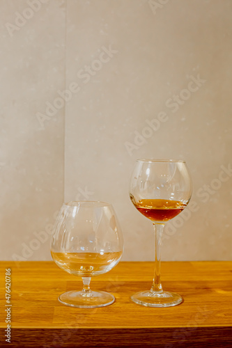 A glass of elite cognac on the bar. Wooden table background. Hard strong alcoholic drinks, spirits and distillates in glasses: vodka, cognac, tequila, scotch, brandy and whiskey, grappa, vermouth, rum