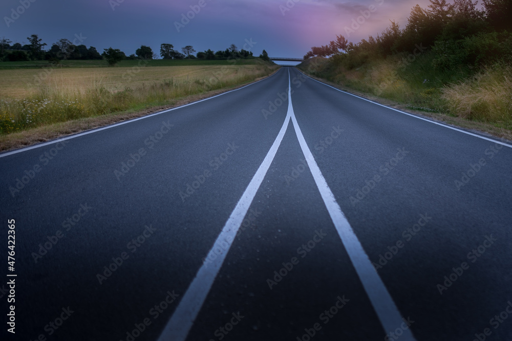 Road crossing plains at sunset. Road to far away.