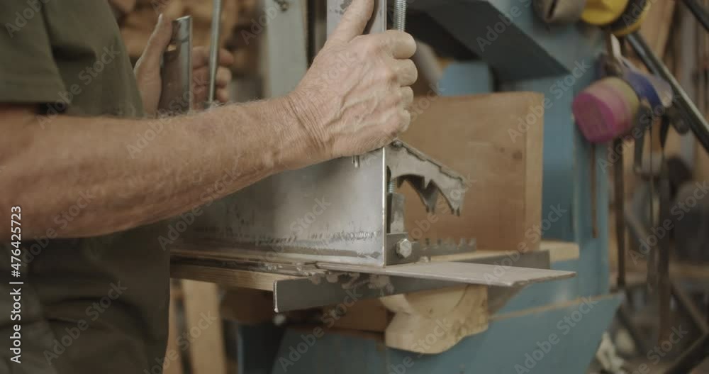 Carpenter slides in a metal plate on a saw Carpenter slides in a metal plate on a saw