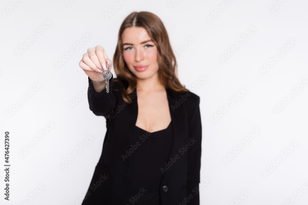 Opening your own business concept. Smiling business woman holding a home keys or real estate agent showing keys from new house, isolated over white background Opening your own business concept. Smiling business woman holding a home keys or real estate agent showing keys from new house, isolated over white background