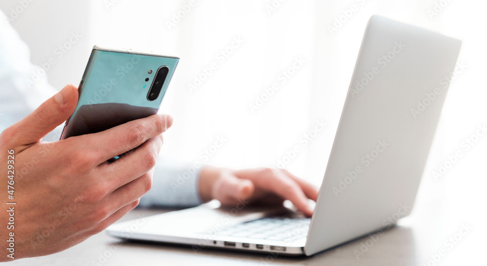 person using laptop and smartphone person using laptop and smartphone