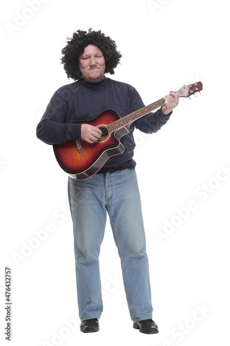 in full growth. curly-haired mature man with a guitar.