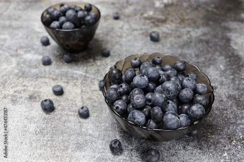 Delicious organic blueberries in a bowl on a dark background. Healthy food concept.