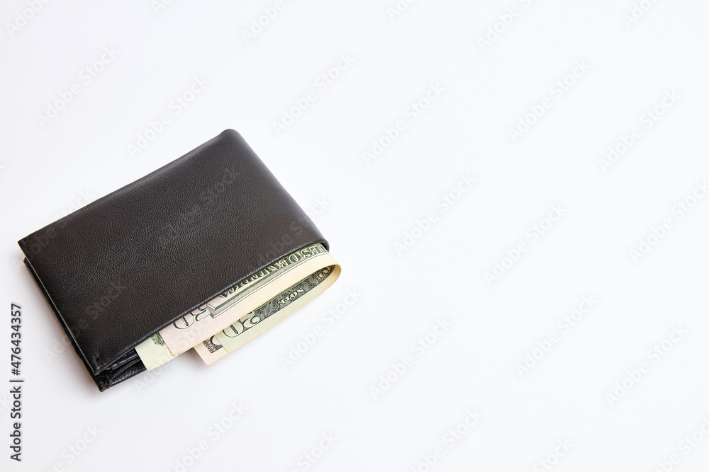 Dollar bills look out of a black leather wallet. The concept of financial security. Dollar bills look out of a black leather wallet. The concept of financial security.