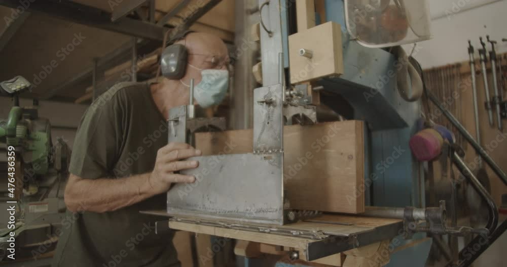 Carpenter wearing a mask while cutting wood Carpenter wearing a mask while cutting wood