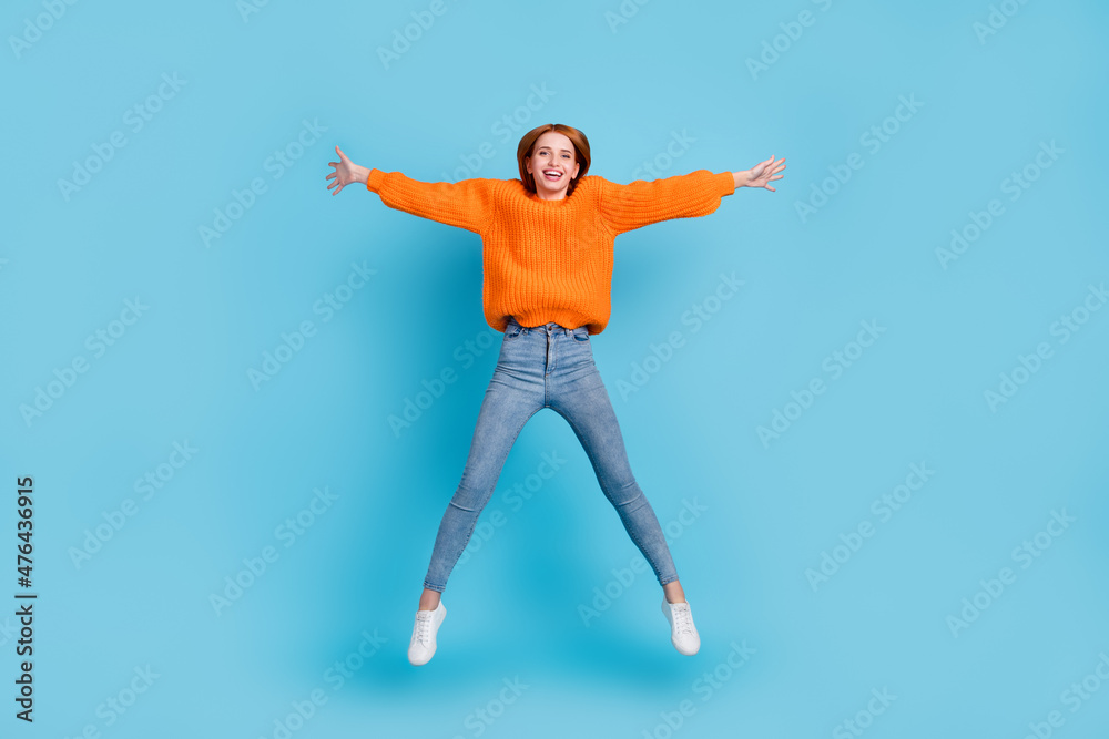 Full length body size view of pretty cheerful girl jumping having fun isolated over bright blue color background