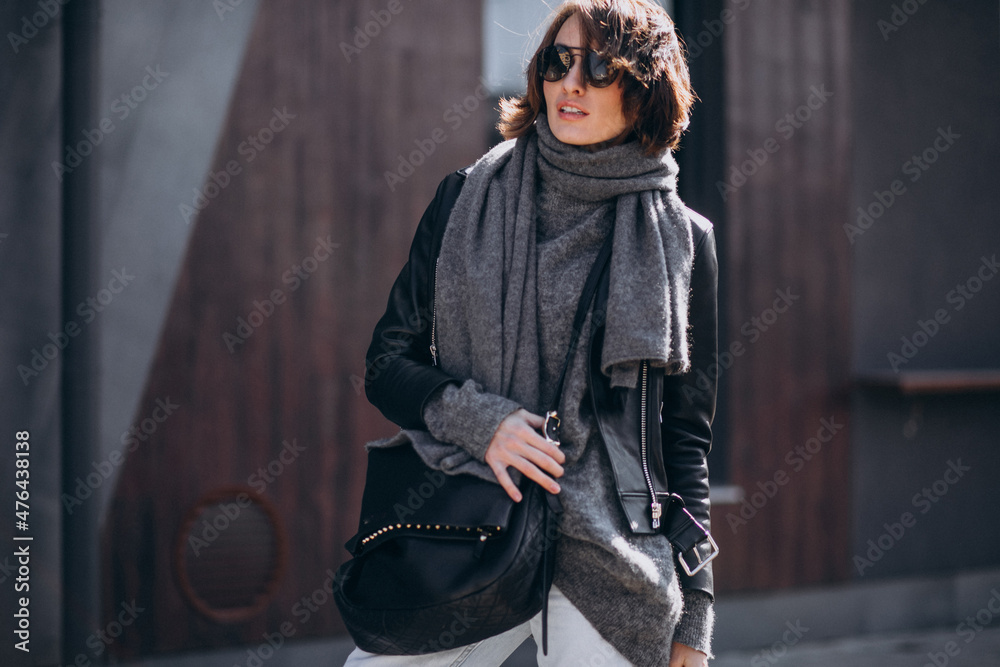 Naklejka premium Young woman model in leather jacket outside the street