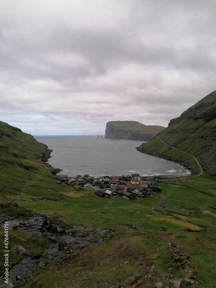 Traditional old cute stone houses with grass roofs on the Faroe Islands with a mountain view Traditional old cute stone houses with grass roofs on the Faroe Islands with a mountain view