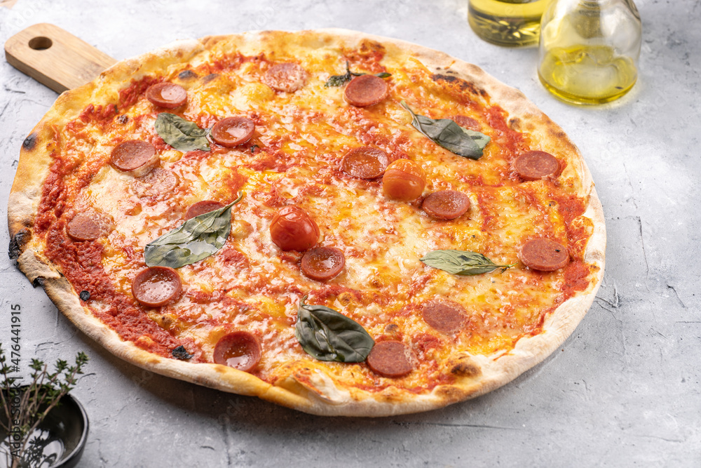 Freshly baked traditional mediterranean pizza with tomato sauce marinara, mozzarella cheese, pork sausage salsiccia and basil