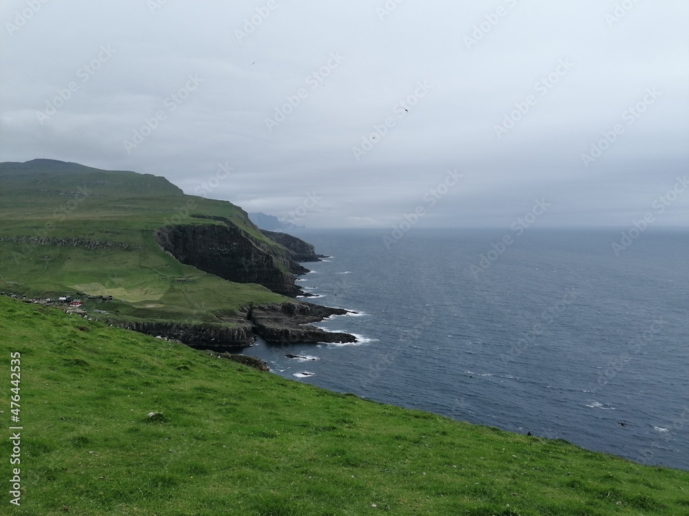 Dramatic cliffs, mountains and coastline on the lush Faroe Islands in the Atlantic Ocean Dramatic cliffs, mountains and coastline on the lush Faroe Islands in the Atlantic Ocean