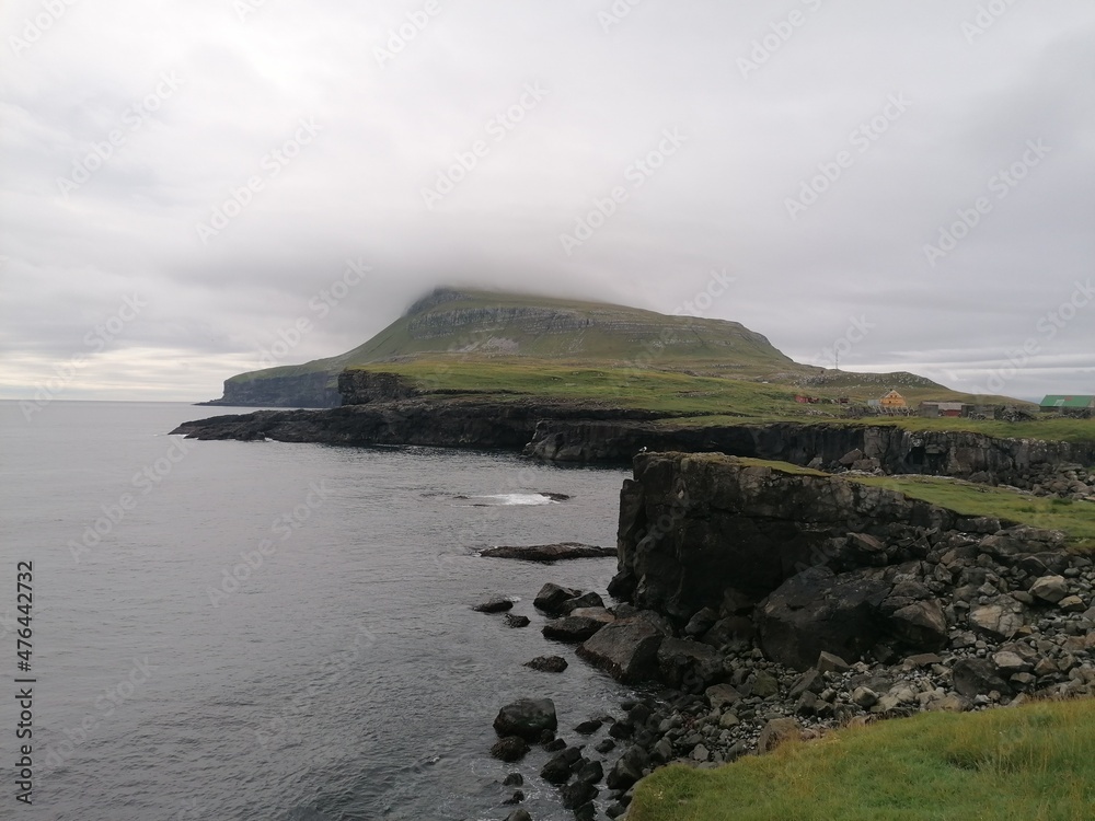 Dramatic cliffs, mountains and coastline on the lush Faroe Islands in the Atlantic Ocean Dramatic cliffs, mountains and coastline on the lush Faroe Islands in the Atlantic Ocean