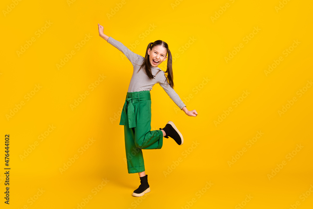 Full body profile side photo of young school girl happy positive smile have fun isolated over yellow color background