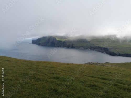 Mountain Hiking in the lush a green hills of the misty Faroe Islands
