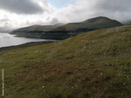 Mountain Hiking in the lush a green hills of the misty Faroe Islands