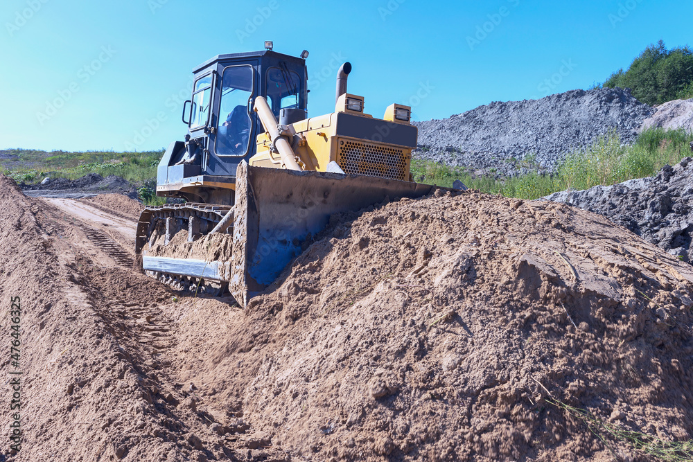 the process of leveling sand with a modern bulldozer during the construction of a dirt road the process of leveling sand with a modern bulldozer during the construction of a dirt road