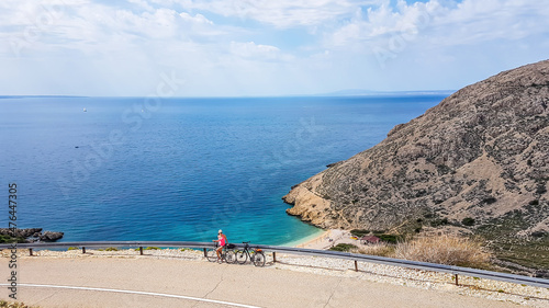 Εκτύπωση καμβά A girl in a sporty outfit, standing on the bike, on the side of a steep road