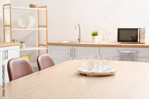 Dining table with glasses of water in modern kitchen © Pixel-Shot
