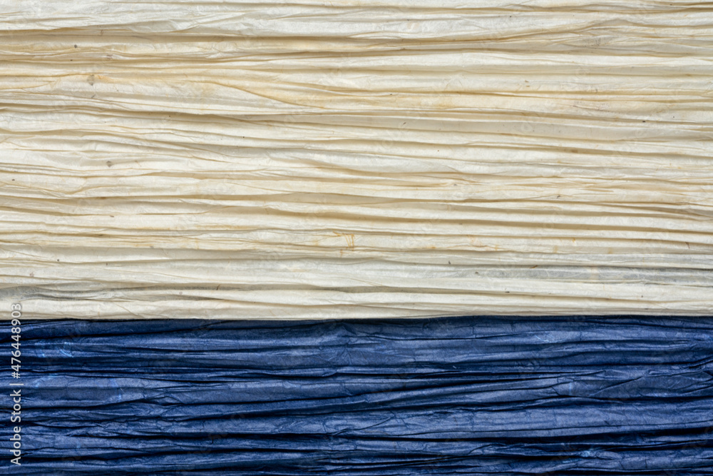 Fototapeta premium background and texture of Thai pleated Unryu mulberry paper, lightweight, soft, translucent and vibrant - navy blue and natural