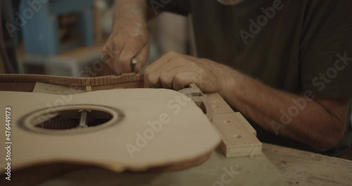 Luthier cutting cracks in a guitar mold