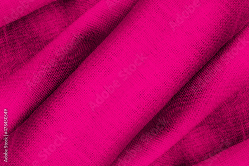 Top view of folded magenta color linen fabric with shallow depth of field for background