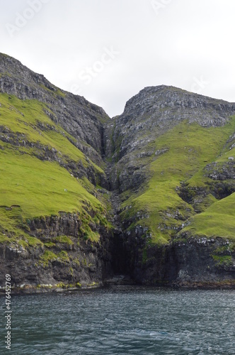 The green and blue dramatic and wild coastal landscapes in the Faroe Islands