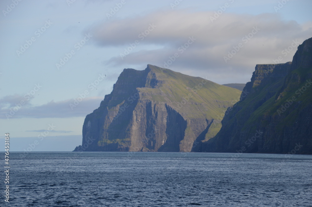 The green and blue dramatic and wild coastal landscapes in the Faroe Islands The green and blue dramatic and wild coastal landscapes in the Faroe Islands
