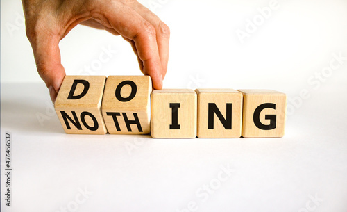 Doing or nothing symbol. Businessman turns wooden cubes and changes the word Nothing to Doing. Beautiful white background, copy space. Business, doing or nothing concept.