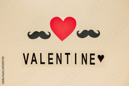 Word VALENTINE with paper mustaches and heart on light background. LGBT concept